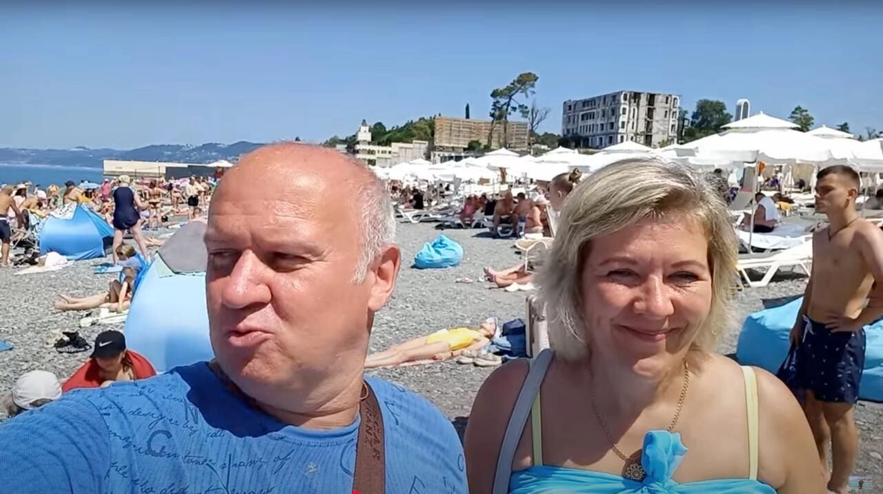 Семейная пара на фоне переполненных пляжей в Сочи