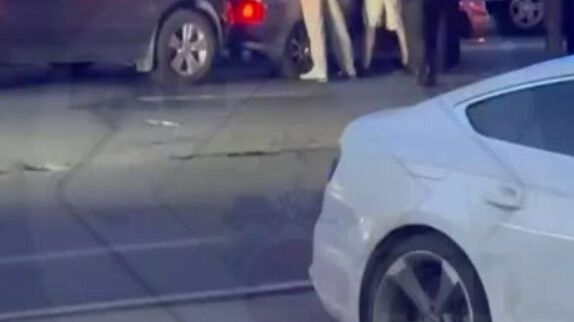 Полицейские задерживают молодых людей, устроивших перестрелку. Участники потасовки стоят вдоль автомобиля, их обыскивают.
