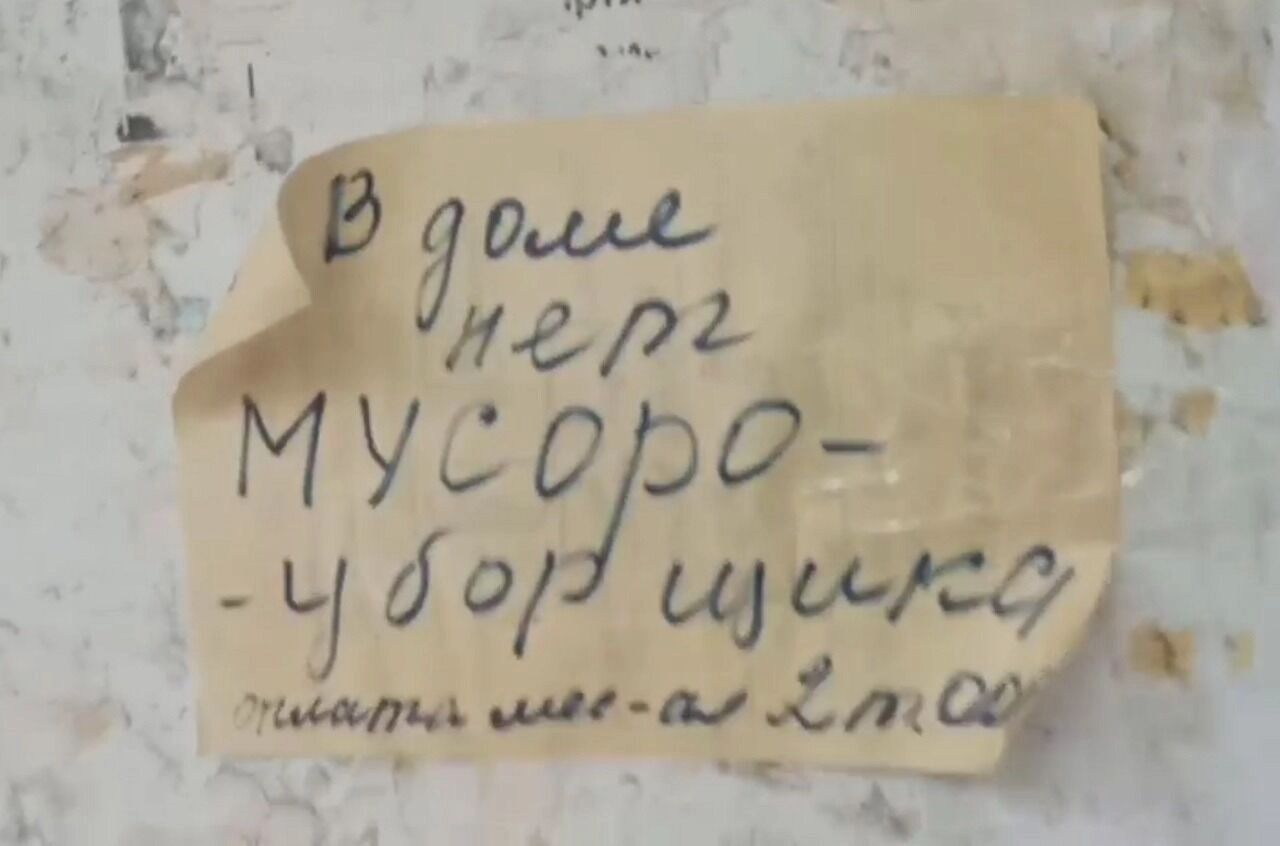 Скриншот видео: на дверях подъезда висит объявление: мусоросборщик дом больше не обслуживает