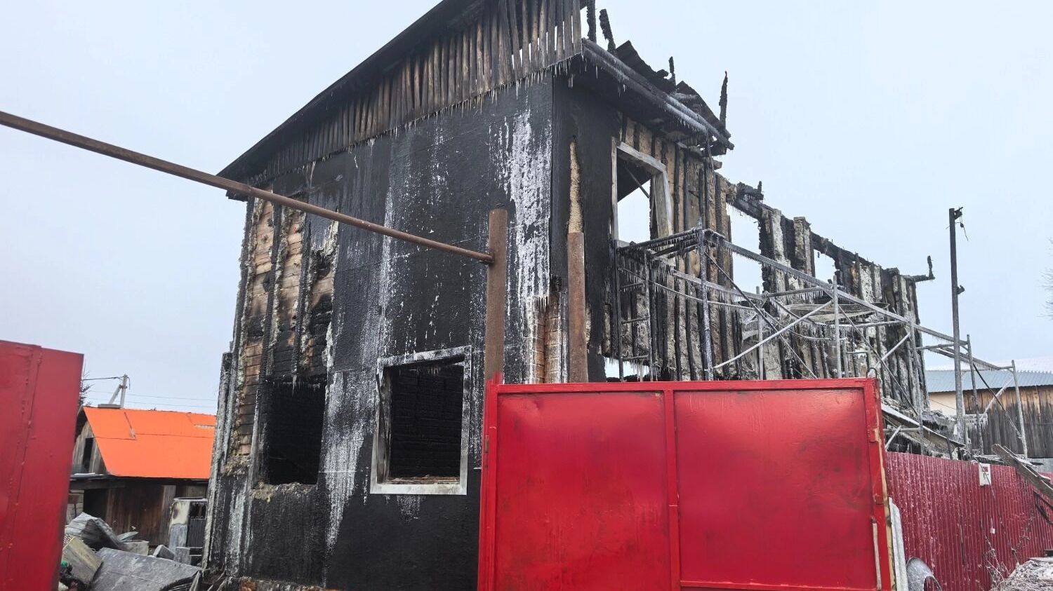 Возле горевшего дома постоянно дежурили сотрудники МЧС, они ждали прибытия следователей