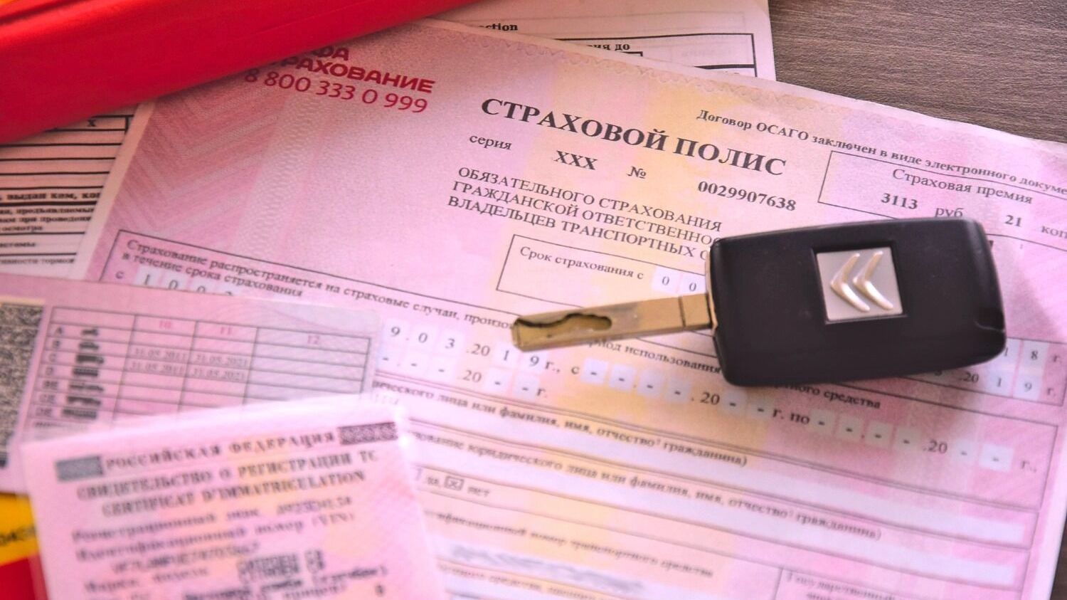 Ключ от машины и страховой полис на автомобиль
