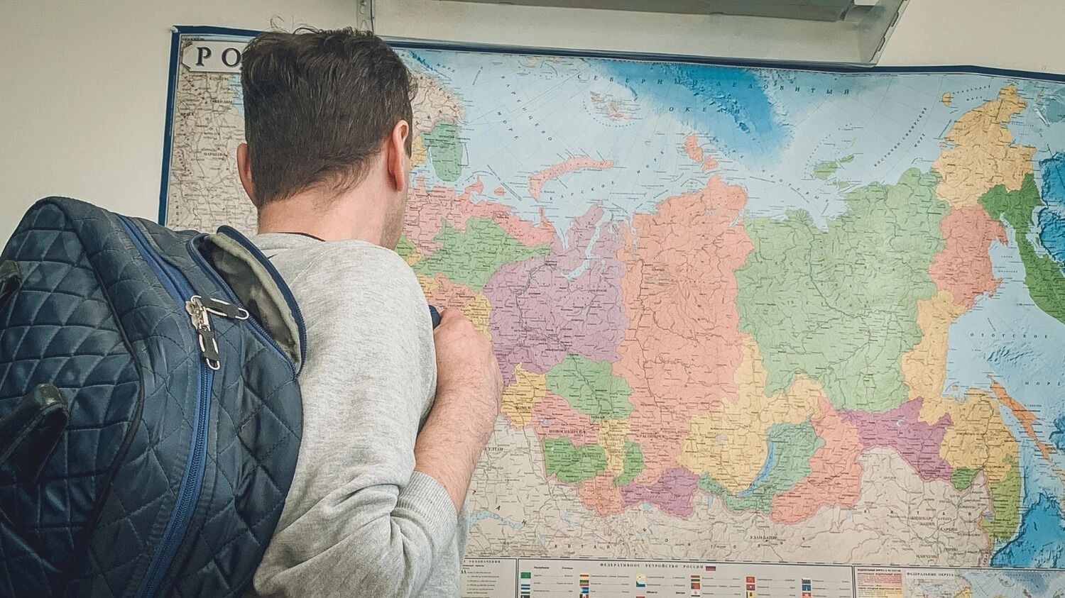 Человек с рюкзаком на фоне карты России