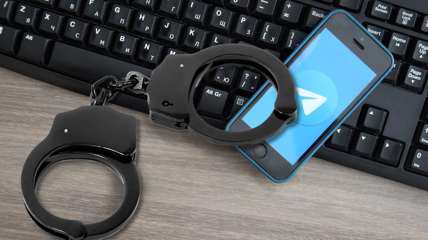 Наручники на фоне смартфона с приложением Telegram