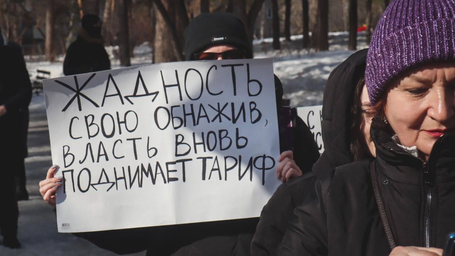 Люди на митинге с плакатами против роста тарифов ЖКХ