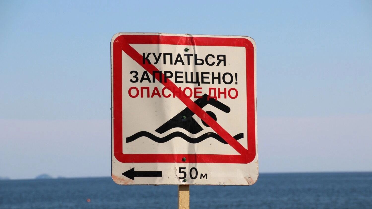 На фото: знак о запрете купания на пляже