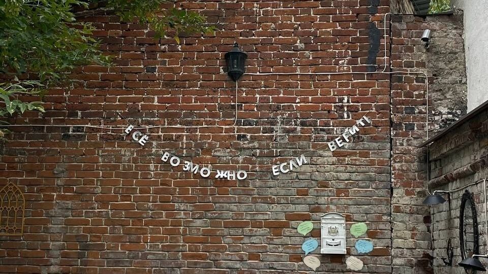 Надпись во дворике католической церкви. Под ней - почтовый ящик для писем Богу.