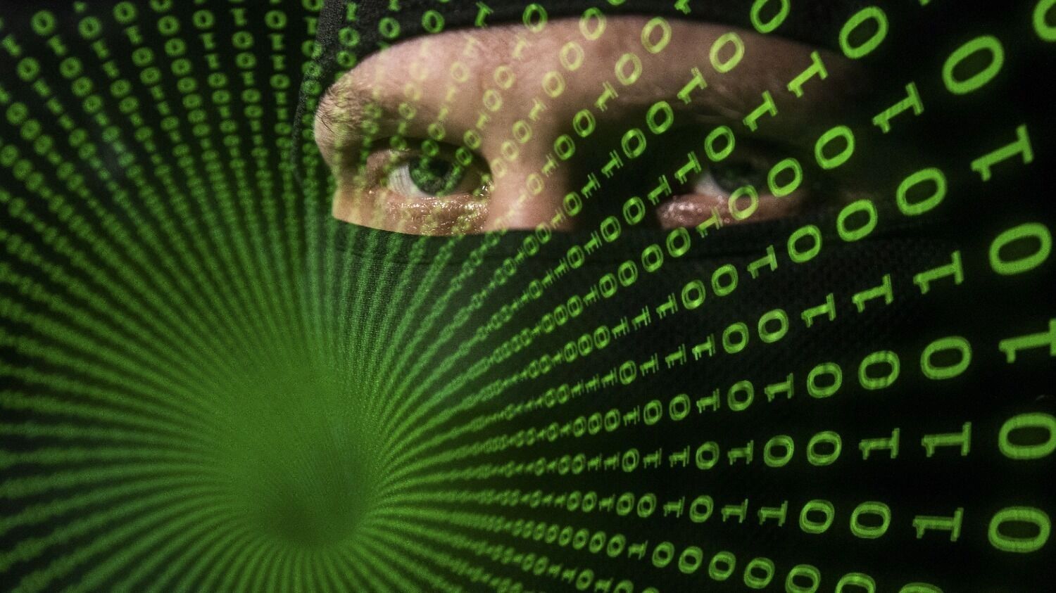 Лицо хакера в&nbsp;маске на&nbsp;фоне цифровых кодов