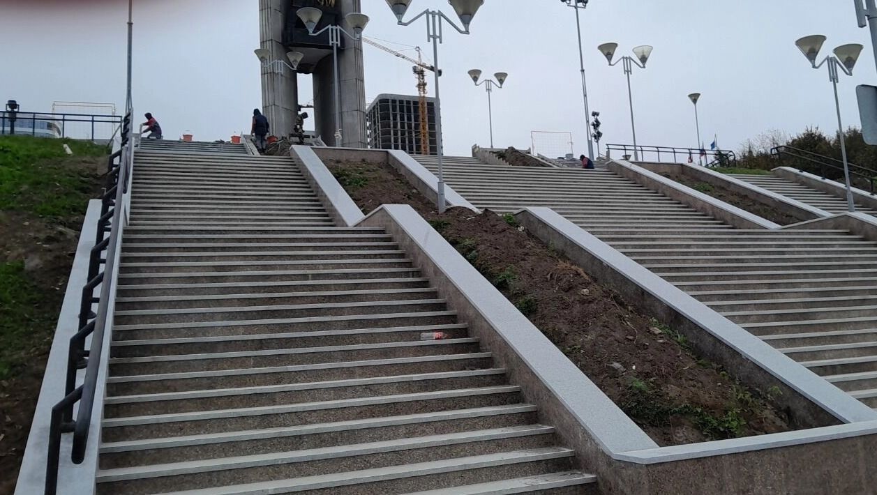 Строители делают облицовку ступеней, вид со&nbsp;стороны пруда