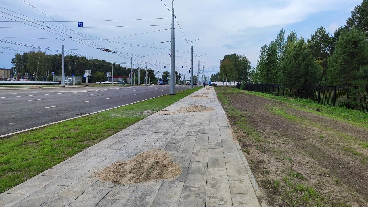 Кучи песка на пешеходных дорожках вдоль бульвара Архитекторов
