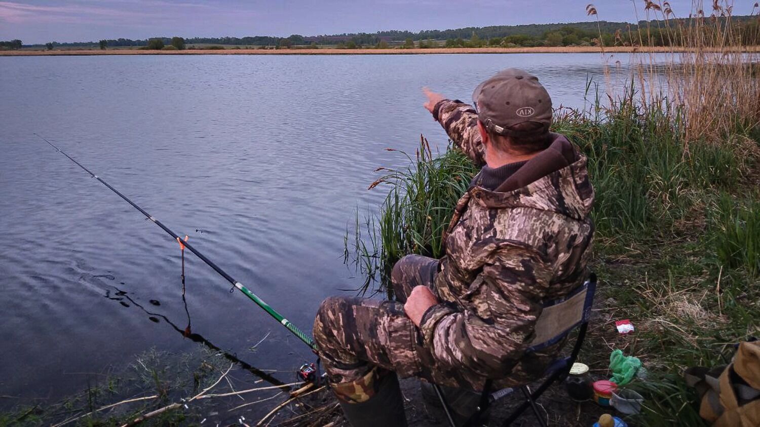 На&nbsp;фото: рыбак сидит с&nbsp;удочкой на&nbsp;берегу